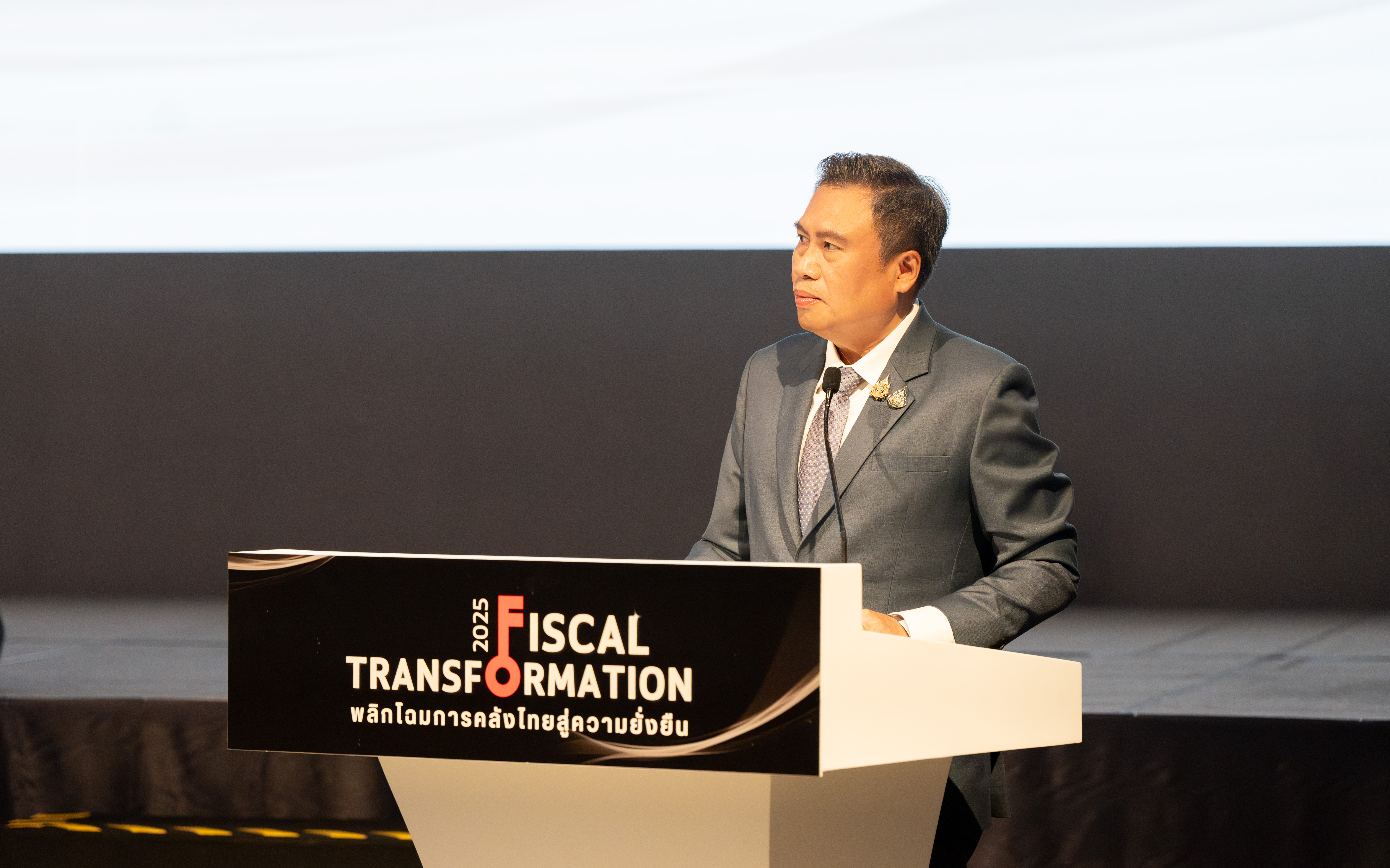 นายพรชัย ฐีระเวช ผู้อำนวยการสำนักงานเศรษฐกิจการคลัง กล่าวรายงานในงานสัมมนา  